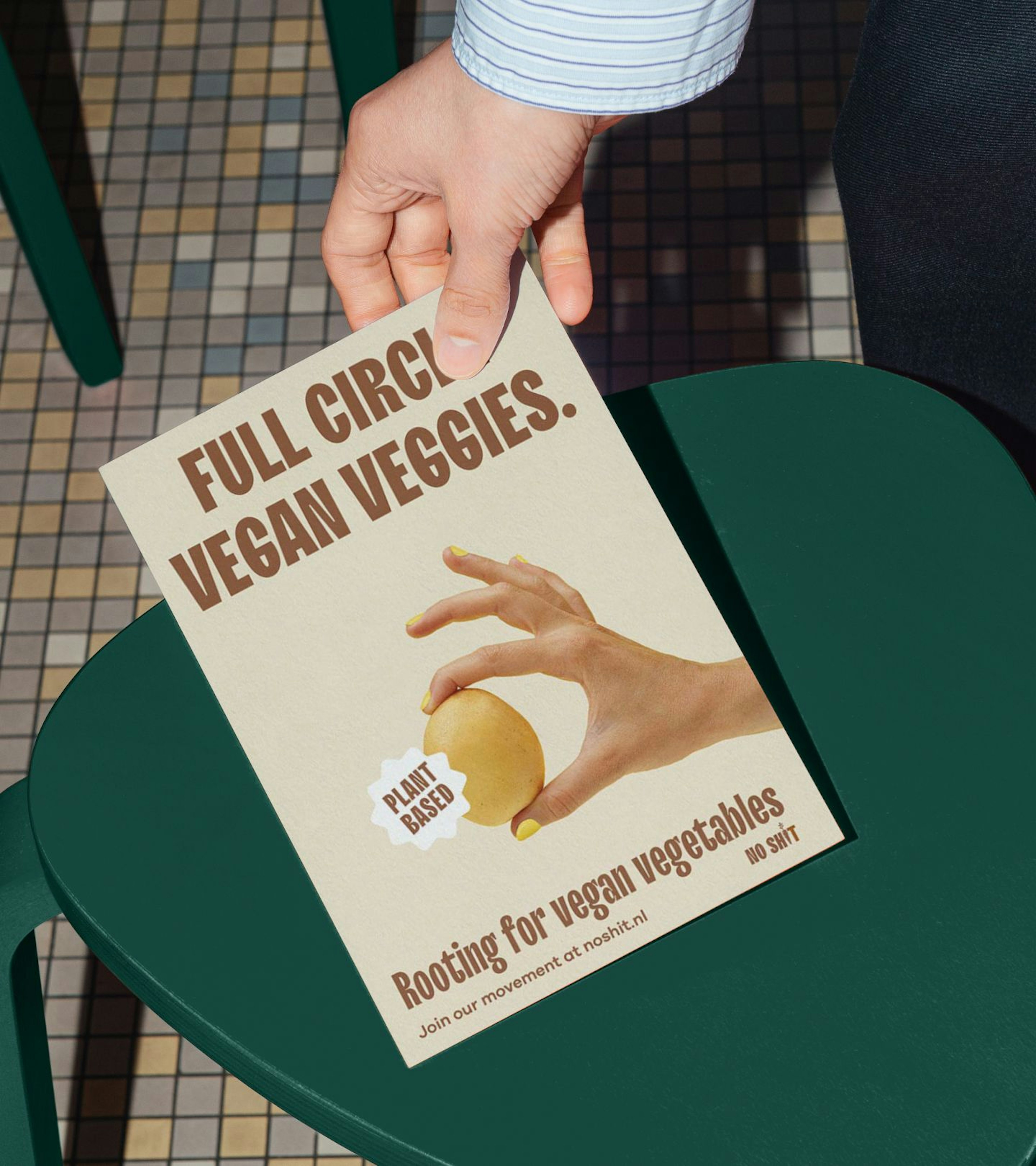 An image of someone with a blue blouse holding a flyer and wanting to put it down on a green stool