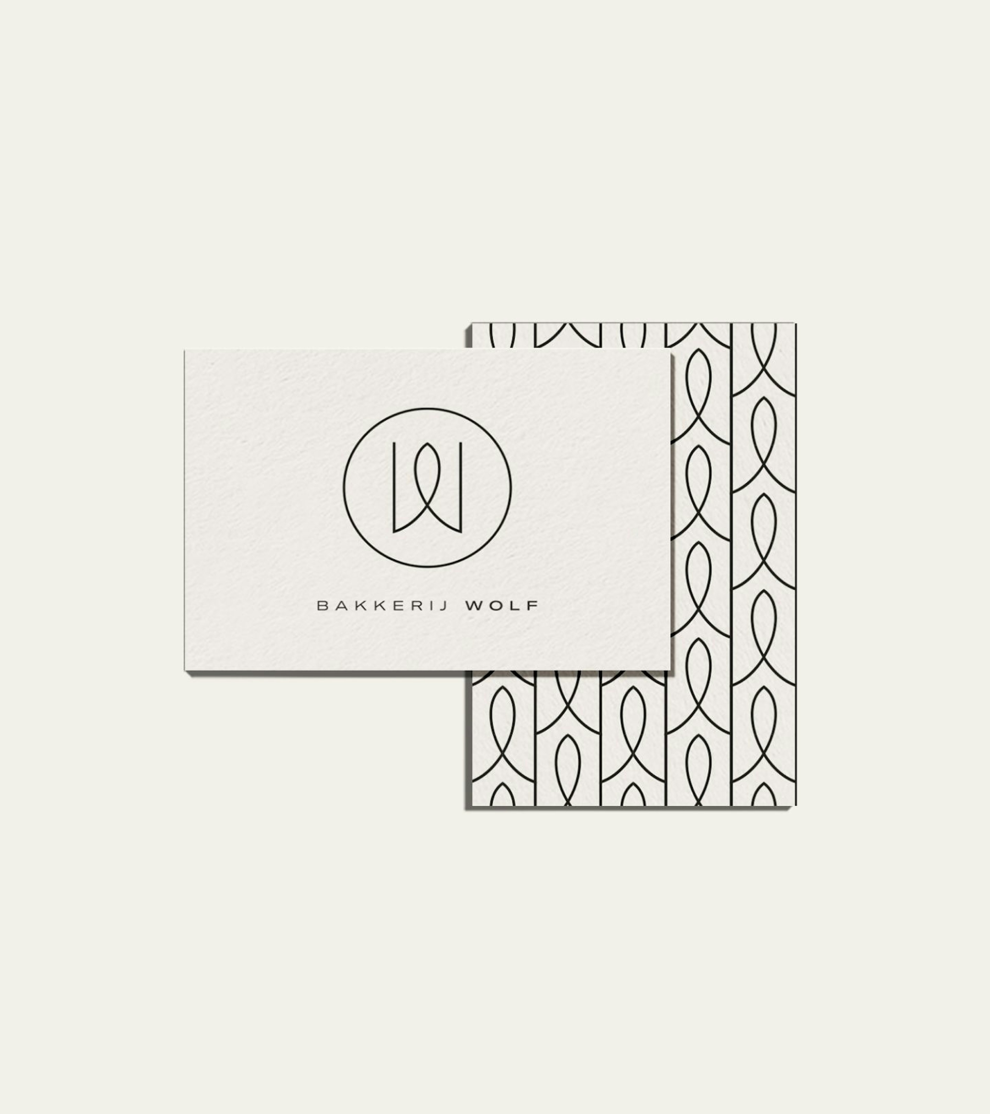 Two business cards both horizontal and vertical with the logo and pattern of Wolf Bakerij