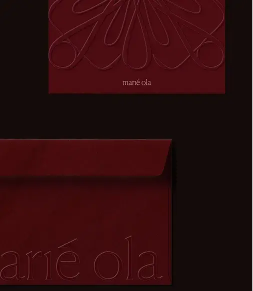 Red embossed envelope and card with elegant swirling design and the text "marié ola."